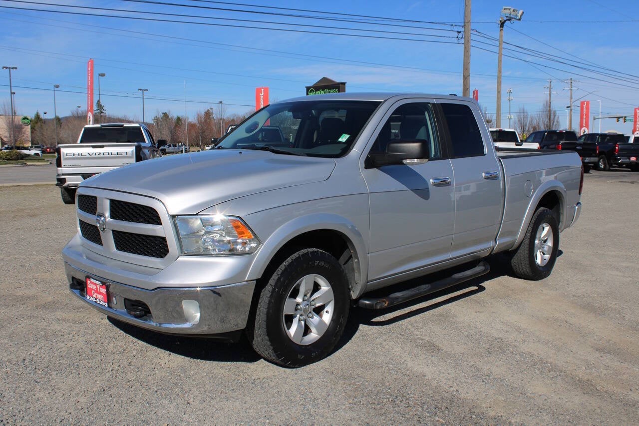 2014 RAM 1500 SLT 4x4 4dr Quad Cab 6.3 ft. SB Pickup in Bright Silver Metallic Clear Coat — front three-quarter view